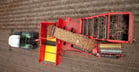 A fully automatic harvesting machine deposits the tubers in an accompanying vehicle or a bunker.